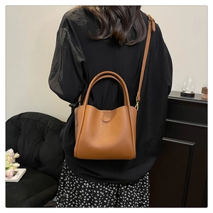 Vue détaillée du sac seau en cuir grainé marron avec poignée et bandoulière amovible