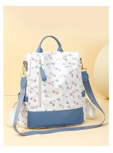 Close-up of floral women's backpack with blue accents and multiple functional pockets