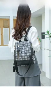 Close-up of black and white checkered backpack with adjustable straps on a model back