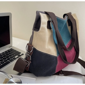 Detail of color-block canvas tote with adjustable strap and metallic side hooks