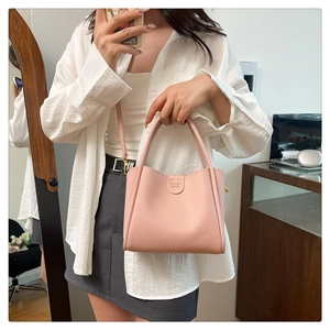 Détail du sac seau rose en cuir PU grainé avec boucle en métal doré et lettrage gravé