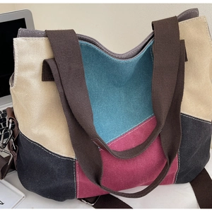 Detail view of large canvas tote bag showing contrast stitching and color-block panels