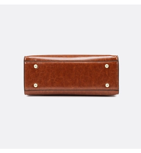Close-up of retro brown oil leather bag base with four protective gold metal studs