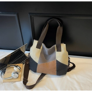 Detail of color-block canvas tote bag with adjustable strap in casual office setting
