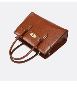 Macro shot of brown faux leather texture and elegant golden oval lock on tote bag