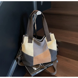 Detail of color-block canvas tote showing thick fabric texture and metallic hooks