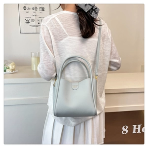 Détail du sac seau en cuir bleu clair avec poignées et bandoulière amovible pour femme