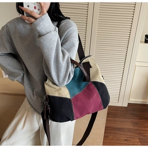 Detail of color-block canvas tote bag with brown straps showing its large size and texture