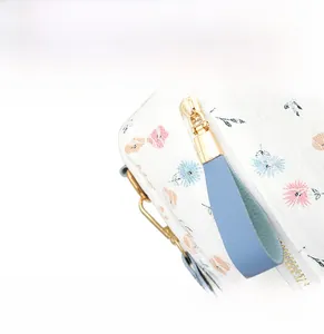 Detail of floral lace fabric on backpack with light blue leather zipper and gold hardware