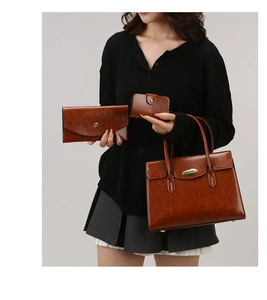 Detailed view of 3-piece vintage brown leather tote set with polished finish and gold hardware