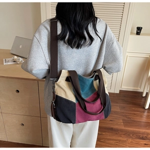 Detail view of large canvas tote bag with multi-color patchwork and wide shoulder strap