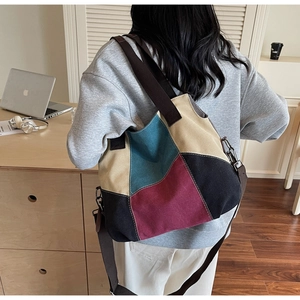 Detail of color-block canvas tote bag with brown strap and silver buckles