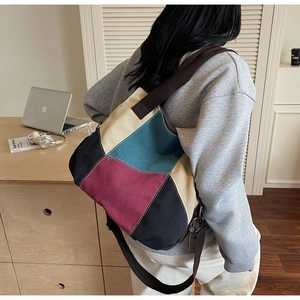 Detail of color-block canvas tote bag showing textured panels and brown strap in lifestyle setting