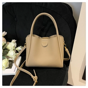 Détail du sac seau kaki minimaliste avec texture cuir grainé et poignées supérieures