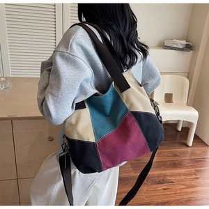 Detail of color-block canvas tote bag with adjustable shoulder strap and metal buckle