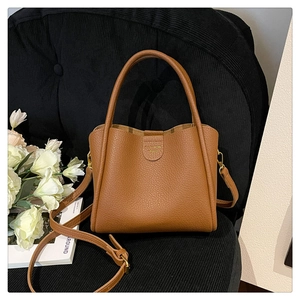 Détail du sac cabas marron en cuir texturé avec lettrage doré de mode élégant