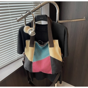 Detail view of multi-color canvas tote featuring patchwork design on black display