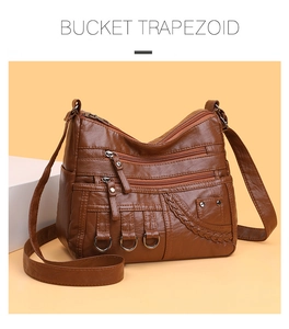 Detailed macro view of brown woven leather bag with multi-zipper pockets and metal rings