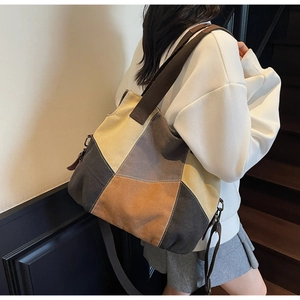 Detail showing the hand-stitched multi-color canvas tote with wide shoulder strap
