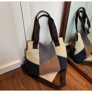 Detail view of multi-color canvas tote bag showing stitching and adjustable shoulder strap