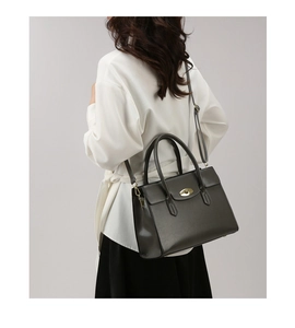 Detail view of the vintage oil wax leather tote with golden oval twist lock and handle