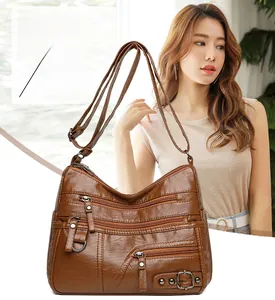 Dettaglio borsa in ecopelle marrone scuro con cerniere multiple e texture di qualità