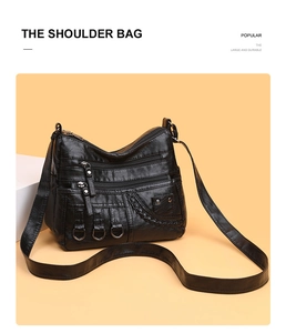 Detail of black pebbled leather shoulder bag showing multiple zip pockets and woven texture