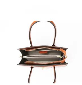 Internal view of brown leather handbag showing spacious compartments and golden zippers