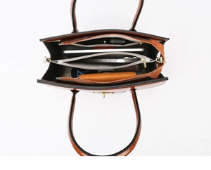 Internal view of the brown leather tote bag with multi-compartment storage and gold zipper