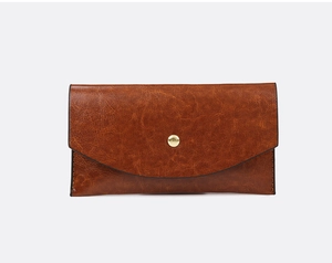 Detail of vintage brown textured leather tote bag flap with golden round metal snap button
