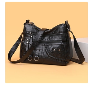 Close-up of black braided shoulder bag showing soft faux leather texture and silver hardware
