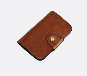 Detail of vintage brown oil leather wallet with round gold snap and clean stitching