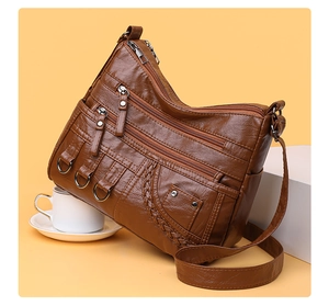 Detail of vintage brown woven tote with multiple zippers and lychee grain leather texture
