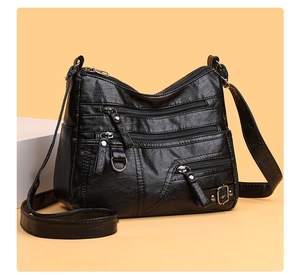 Dettaglio della borsa in ecopelle nera con tasche multiple con zip e finiture argentate
