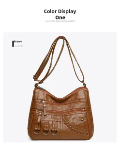 Close-up of brown PU leather crossbody bag featuring multiple zipper pockets and D-rings
