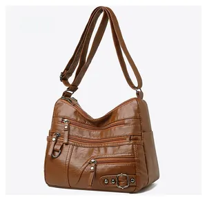 Dettaglio borsa in pelle marrone scuro con triple tasche a zip e anello a D in metallo