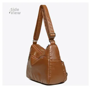 Side view of brown faux leather shoulder bag featuring multiple zipper pockets and texture