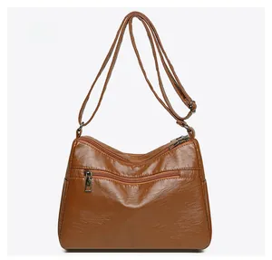 Detailed back view of a brown pebbled leather shoulder bag with multiple zippers