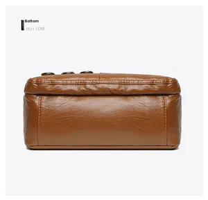 Detailed bottom view of brown leather shoulder bag featuring rich lychee grain texture