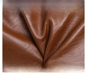 Detail shot of premium brown lychee texture leather showing soft fold and rich grain