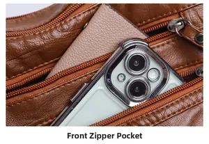Detailed view of the front zipper pocket on a brown lychee textured leather shoulder bag