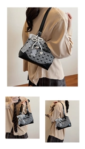 Detail showing houndstooth check bag with white lace, pearls, and heart charms