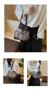Detail of checkered shoulder bag with lace bow and brown leather strap design