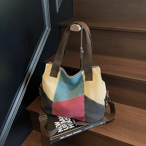 Fashionable color-block canvas tote bag with adjustable strap on a modern urban staircase
