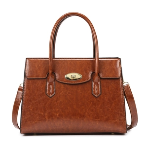 Vintage brown PU leather handbag with dual handles and gold clasp on white background