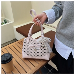 Detailed shot of pink plaid bucket bag featuring lace bow, pearls and heart pendant charm