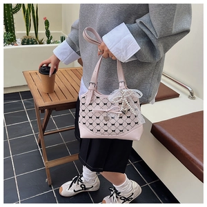 Detailed view of pink bow canvas bucket bag with pearl lace charm and pattern