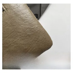 Vue macro montrant la texture du cuir à motif litchi et les détails de couture précis