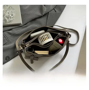 Vue de dessus du sac bandoulière marron foncé avec plusieurs compartiments zippés et rangement