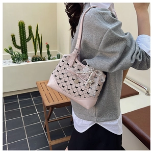 Detailed view of pink plaid crossbody bag with lace bow charms and pearl pendants